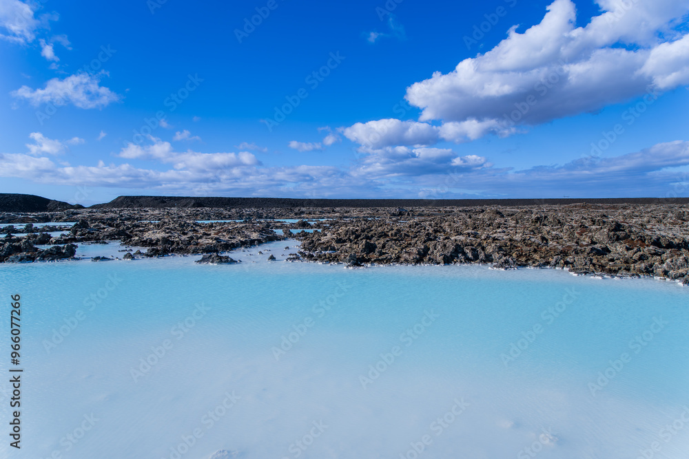 Milky blue waters of the Blue Lagoon in Iceland contrast with black ...