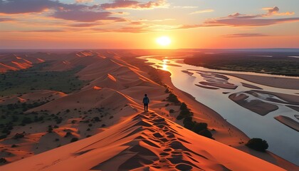 Stunning aerial view of tourists traversing vibrant desert sand dunes beside a red river at sunset