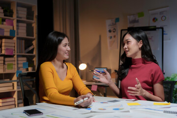 Two businesswomen having a meeting at night in the office