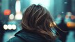 © Maximages  - A view from behind of a person's hair blowing in the wind on a busy city street, perfectly capturing the bustling energy and dynamic movement of urban life.
