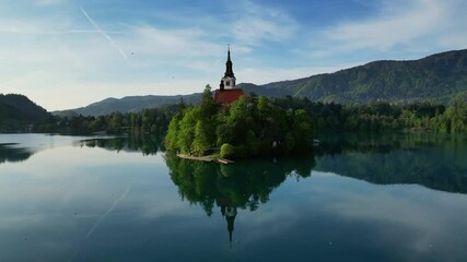 Wall Mural - Aerial around view of Bled lake with the Pilgrimage Church of the Assumption of Maria on a small island in morning light, Slovenia, 4k