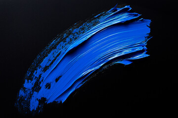Wall Mural - bright blue brush stroke of paint on black background