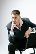 © Elina Leonova - Handsome man, fashion model sits on chair