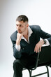 © Elina Leonova - Handsome man, fashion model sits on chair