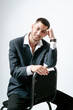 © Elina Leonova - Handsome man, fashion model sits on chair