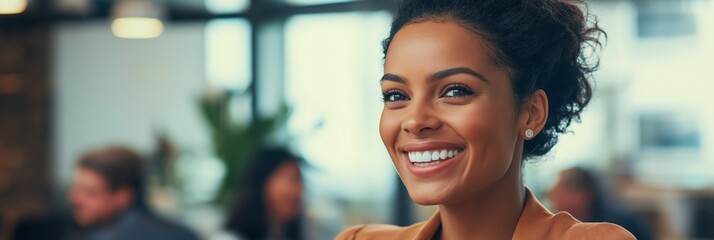 A woman with a smile on her face is standing in front of a group of people. She is wearing a business suit and she is confident and happy