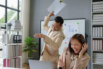 Wall Mural - Asian businessman scolding stressed businesswoman covering face at work