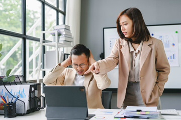 Wall Mural - Businesswoman scolding businessman covering his ears