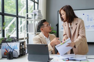 Wall Mural - Businesswoman showing disappointment while discussing with businessman at office desk