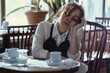 © alisaaa - tired waitress sitting at a cafe table, restaurant waiter with a headache at end of working day, employee resting in a closed cafe, overwork tired waitress sitting at a cafe table, restaurant waiter w