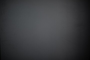 Close-up of a plain dark gray wall with a smooth, slightly textured surface. The minimalist and neutral background is perfect for use in design, presentations, or as a backdrop for creative projects
