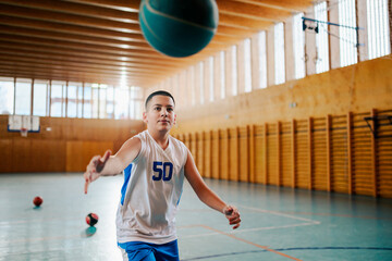 Wall Mural - Young player passing basketball indoors