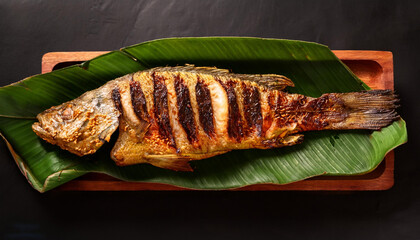 Spicy grilled fish served on banana leaf 