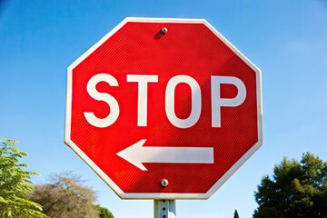 A bright red octagonal stop sign with bold white lettering and a stylized arrow, isolated on a white background, conveying a sense of urgency.