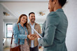 © Drazen - Happy woman shaking hands with real estate agent while buy new home with her husband.