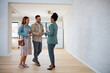 © Drazen - Happy couple of real estate buyers handshaking with their agent in new house.