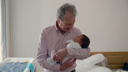 Grandfather holding his newborn grandchild in a cozy room, gazing at the baby with love and joy, capturing a tender moment of family bonding and affection