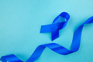 Men's Cancer Fight. Overhead shot of prostate cancer awareness icon - blue ribbon on a gentle blue background, suitable for text or promotional content