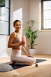 © Drazen - Happy athletic woman having water break while practicing in Yoga studio and looking at camera.