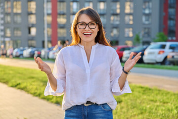 Portrait of positive middle-aged woman posing outdoors