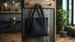 © Helois - Black tote bag hanging on a wooden door in a cafe.