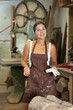 © JackF - Smiling young lady wearing apron standing against background of instruments in woodworkers studio