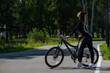 © Михаил Решетников - Caucasian woman riding a bike in a park.