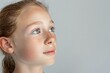 © InfiniteStudio - Portrait of a young girl with skin concerns, looking thoughtfully at the ceiling against a white backdrop in a calm setting