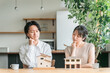 © buritora - 住宅模型を見てマイホームの間取りを検討する若い夫婦（相談会・ハウスメーカー・一戸建て）