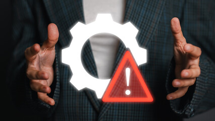 A businessman presenting the concept of risk management using a gear and warning symbol, emphasizing caution and strategic planning.