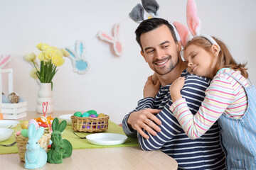 Canvas Print - Cute little girl hugging her father in bunny ears at Easter dinner