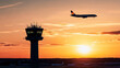 © Creativision - Silhouette of an airplane flying over the control tower at sunset