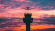 © Creativision - Silhouette of an airplane flying over the control tower at sunset