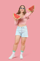 Wall Mural - Beautiful young happy woman in sunglasses with slices of fresh watermelon on pink background