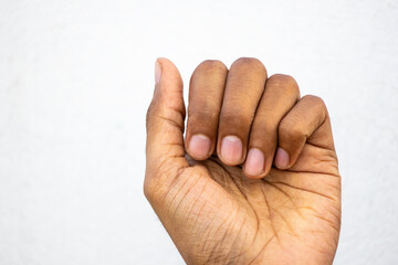 Close-up of a young man hands with neatly manicured short fingernails against white background.