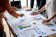 © Wasana - Business people analyzing financial charts and graphs on table