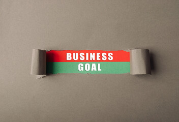 A business goal is written on a piece of paper that is torn in half