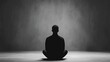 © Intelligent Horizons - A lone person sitting in an empty room enveloped by a shroud of dark ominous shadows that loom over them creating an atmosphere of psychological dread and isolation