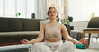 © PeakPoints/peopleimages.com - Home, meditation and woman with fitness, yoga and healthy girl with routine, calm and spiritual in lounge. Apartment, yogi and person in living room, chakra and lotus for wellness, zen and balance