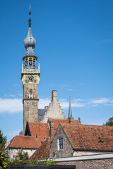 Town Hall of Veere stadhuis in Dutch. impressive gothic building landmark in popular historic zeeland destination houses museum with quiet street road in foreground on sunny blue sky summer day 