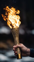 Wall Mural - A hand holds a golden torch with a bright flame burning.