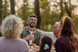 © bernardbodo - Family enjoying drinks and food at picnic