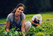 © StarDweller/peopleimages.com - Smile, farm and portrait of woman with plants, eco sustainability and agriculture in green field. Nature, vegetables and happy agro farmer with small business, food production and team in countryside
