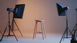© Sahraya - An empty stool is positioned amid professional lighting equipment in a photo studio. The lighting setup is strategically arranged to provide optimal illumination for photography, highlighting the stoo