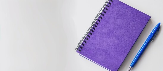 Poster - Purple notebook and blue pen viewed from above on a white background making it suitable for school or office themed wallpapers with a flat lay composition and ample copy space image