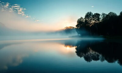 Wall Mural - Misty lake at sunrise with peaceful water and tree silhouettes