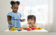 © Art_Photo - Two diverse children playing with colorful wooden blocks early childhood education, learning and development fun activities for kids in preschool, creative playtime, cognitive growth, friendship