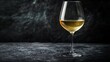 © cac_tus - Glass of white wine on dark textured surface, elegance and sophistication concept