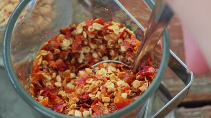 Wall Mural - Close-up, ground chili flakes dazzle with their fiery red and orange hues.