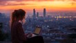 © fotofabrika - A young woman working on a laptop at sunset overlooking Barcelona city from a scenic viewpoint